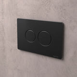 NATIVA Placca Bolla JP2NM nero opaco con pulsanti tondi installata su parete in cemento vista laterale